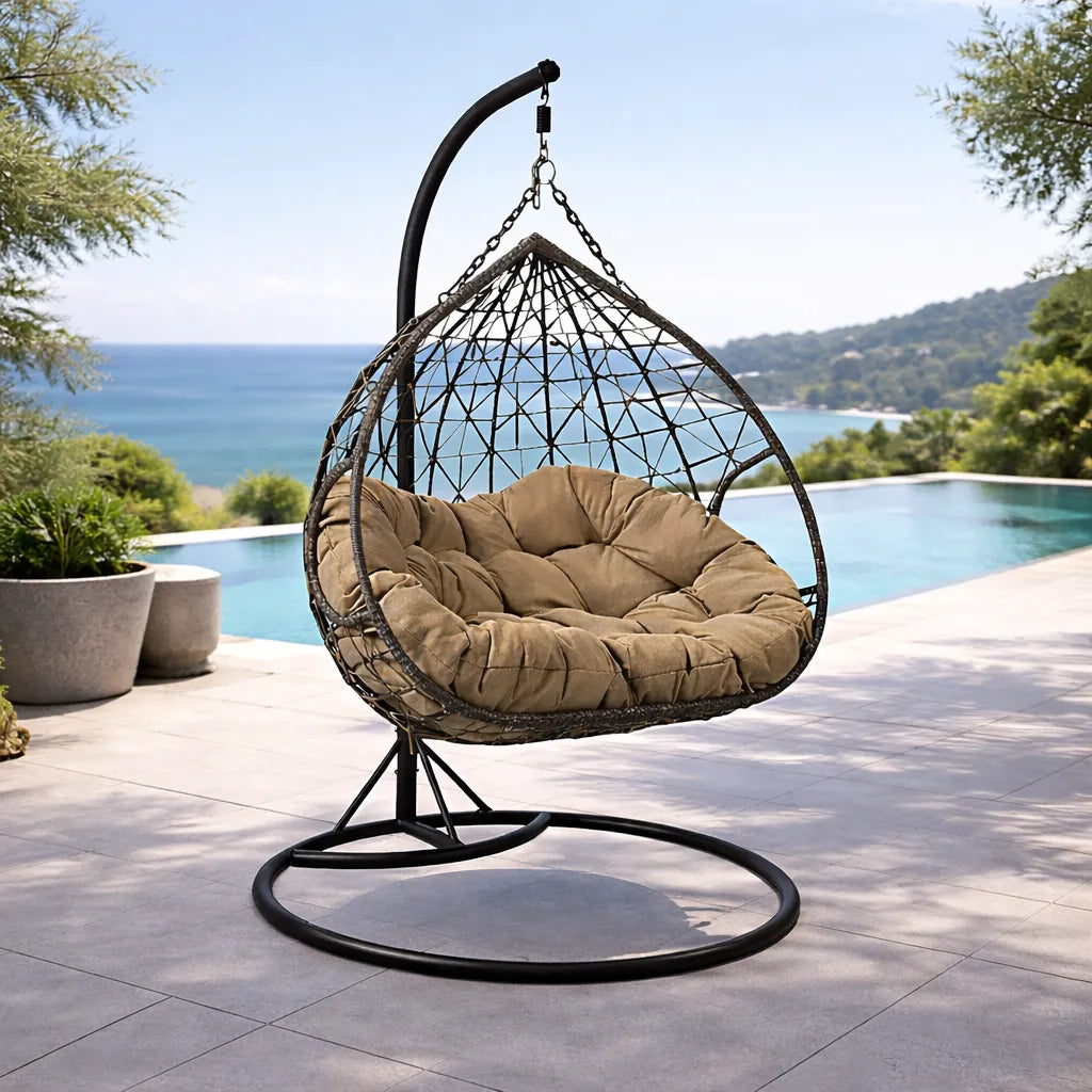 Poltrona sospesa Lita XL a uovo in rattan intrecciato con struttura in acciaio verniciato e cuscino imbottito. Dondolo elegante per giardino e esterni.