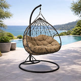 Poltrona sospesa Lita XL a uovo in rattan intrecciato con struttura in acciaio verniciato e cuscino imbottito. Dondolo elegante per giardino e esterni.