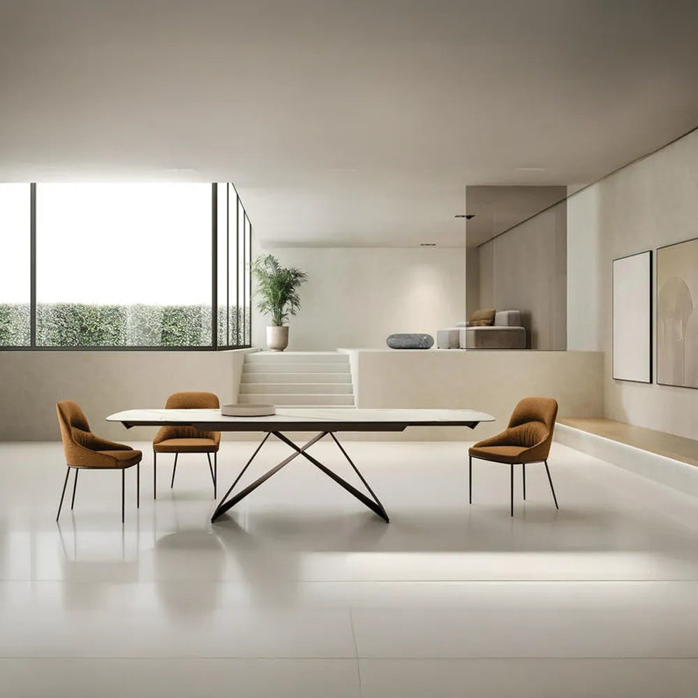 Tavolo Thanos X allungabile con piano in ceramica effetto marmo Calacatta Oro e struttura in metallo bronzo